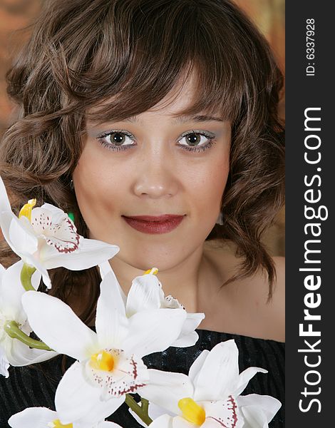 Portrait of the beautiful young woman with a white orchid