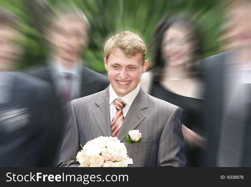 The joyful groom with a bouquet goes to the bride