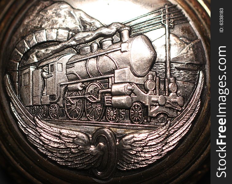 Photo of an old silver watch with a train on it. Photo of an old silver watch with a train on it.