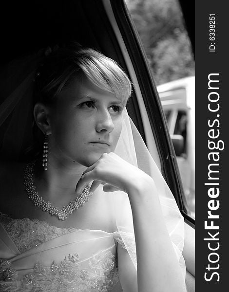 The thoughtful bride looks out of the window a limousine
