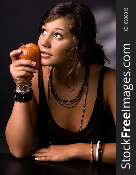 The girl with an apple on a black background