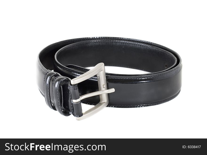 Classic black leather belt, rolled up, isolated against white