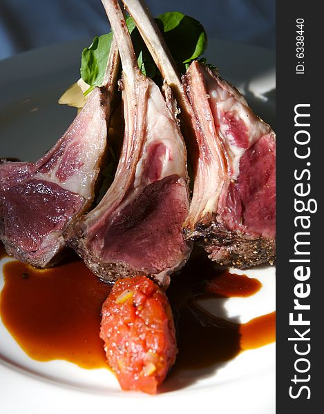 An image of gourmet lamb chops with garnishes