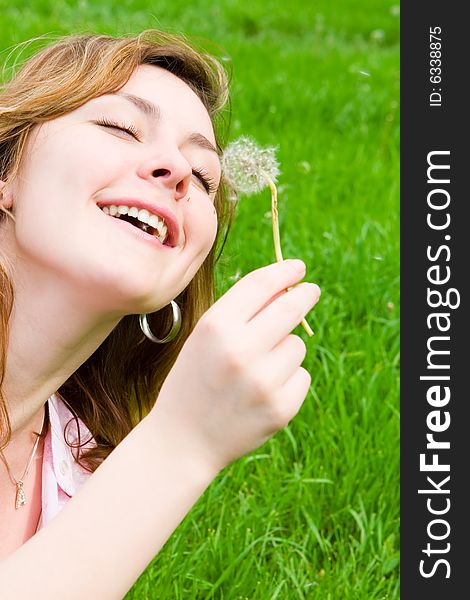 Girl blowing on the dandelion