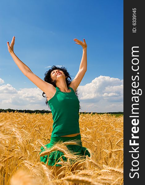 Happy woman jumping in golden wheat