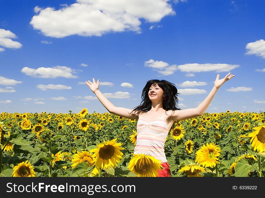 Happy woman in the field of sunflowers