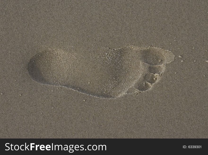 A footprint of a bare foot on the beach. A footprint of a bare foot on the beach.