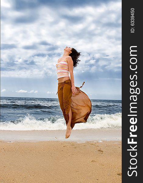 Young woman is jumping in the beach