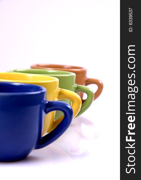 Color coffee cups in line with focus on yellow cup