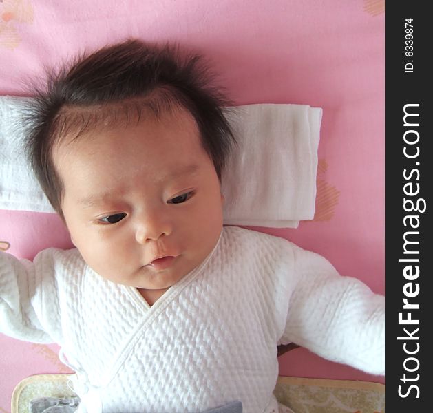 A Chinese infant on a bed. A Chinese infant on a bed