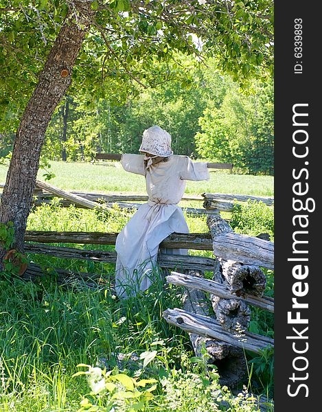 Scarecrow Perched On Fence