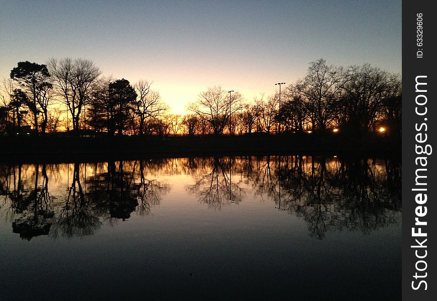 Trees Reflecting in Water Surface during Sunset in Winter.