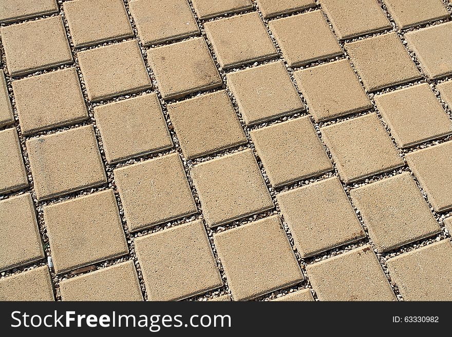 Patterned light brown paving street tiles on the road. Patterned light brown paving street tiles on the road