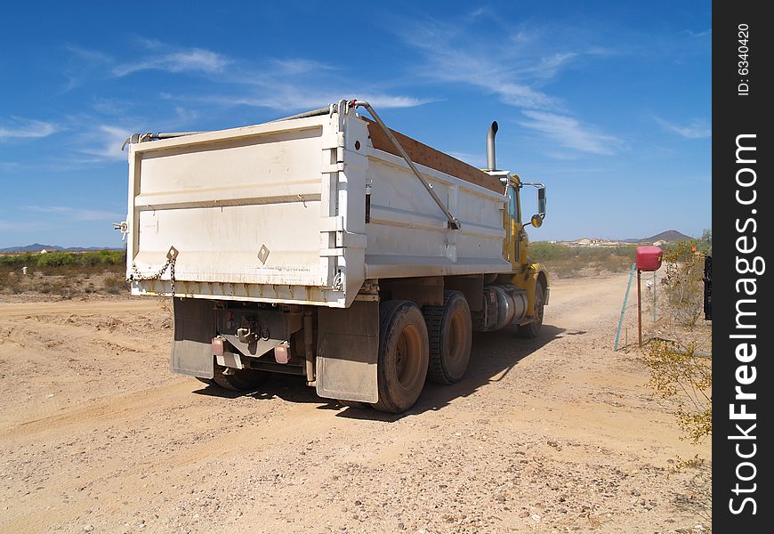 A dump truck is parked in a desert excavation area.  Horizontally framed shot. A dump truck is parked in a desert excavation area.  Horizontally framed shot.