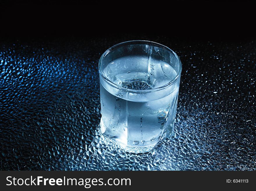 Glass of very cold water standing on dark background. Glass of very cold water standing on dark background