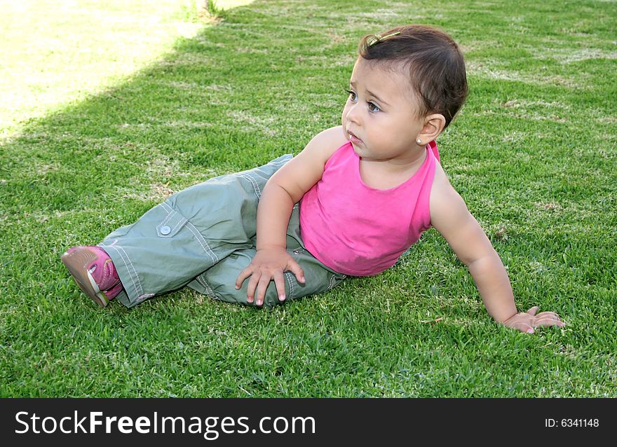 Little pretty girl in pink on green grass. Little pretty girl in pink on green grass.