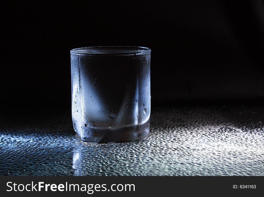 Glass of very cold water standing on dark background. Glass of very cold water standing on dark background