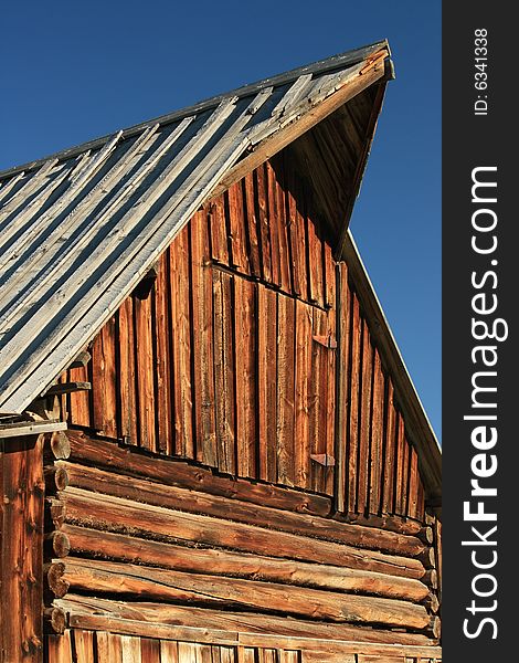 Close-up of peaked gable and side of old log barn construction. Close-up of peaked gable and side of old log barn construction