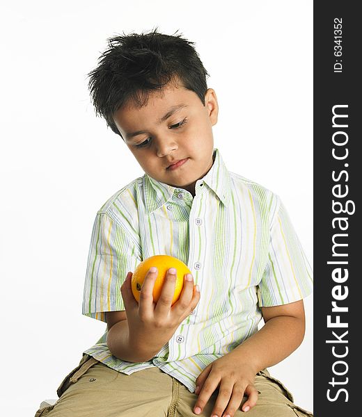 Asian Boy Looking At An Orange