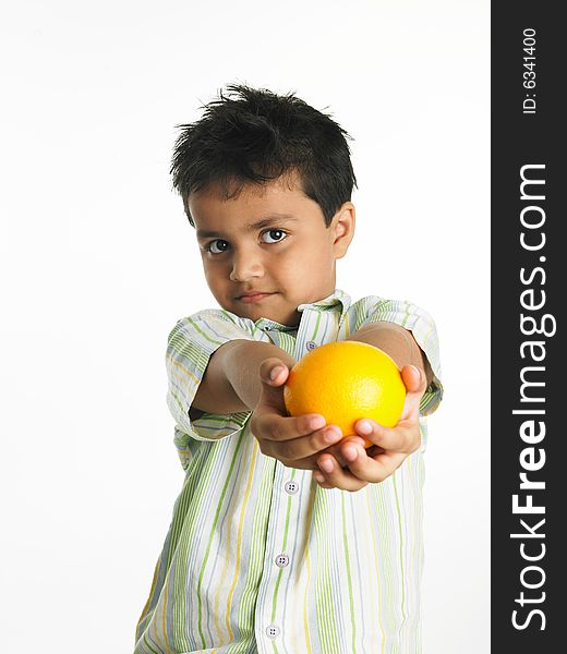 Asian boy of indian origin with an orange. Asian boy of indian origin with an orange