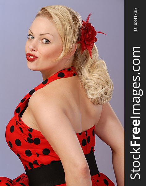 Portrait of gorgeous fifties style pinup blond in red polka-dot dress. Portrait of gorgeous fifties style pinup blond in red polka-dot dress