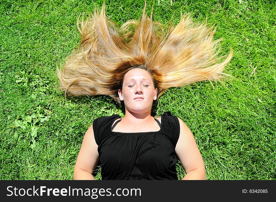 A woman in a field taking a break from work. A woman in a field taking a break from work