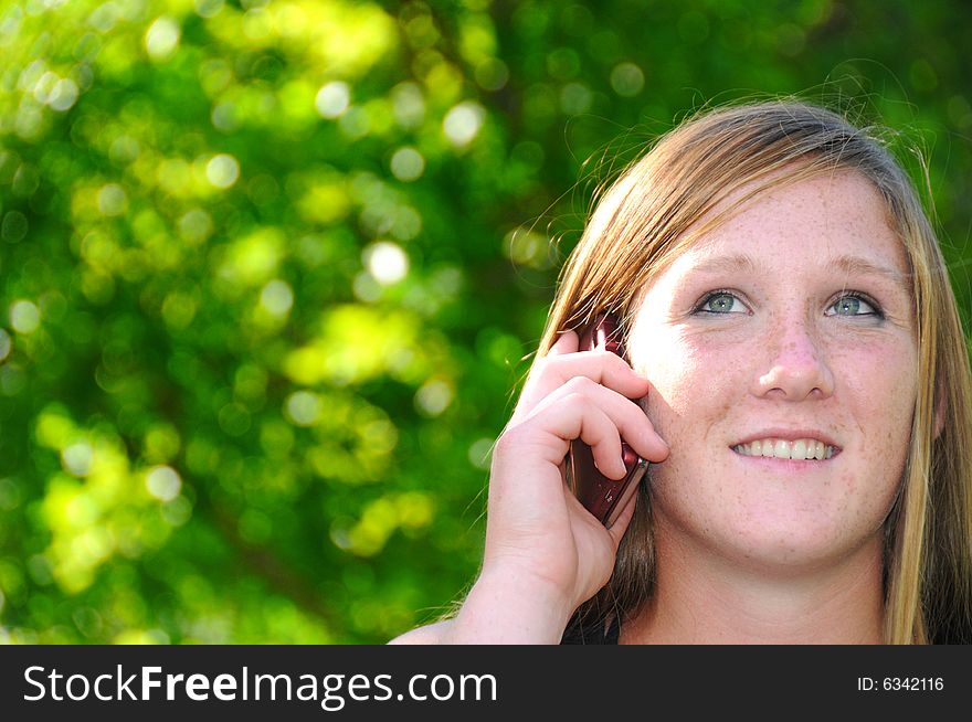 Woman talking on her cell phone in the park. Woman talking on her cell phone in the park