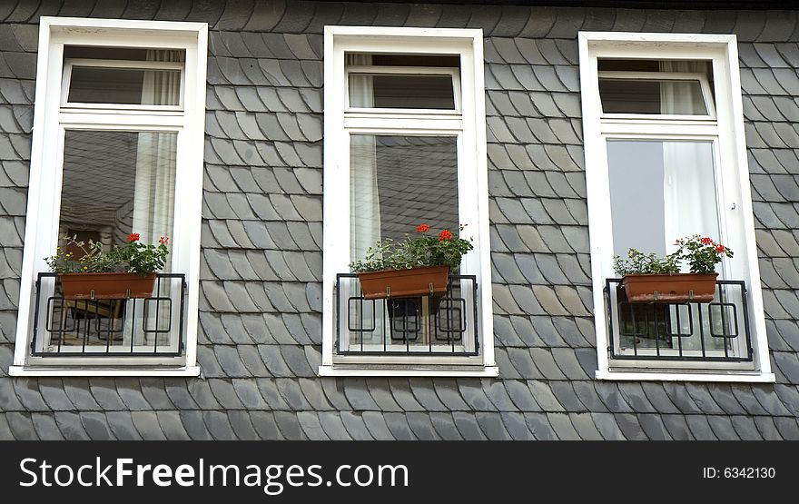 Three windows in a wall made of slate. From Goslar, Germany