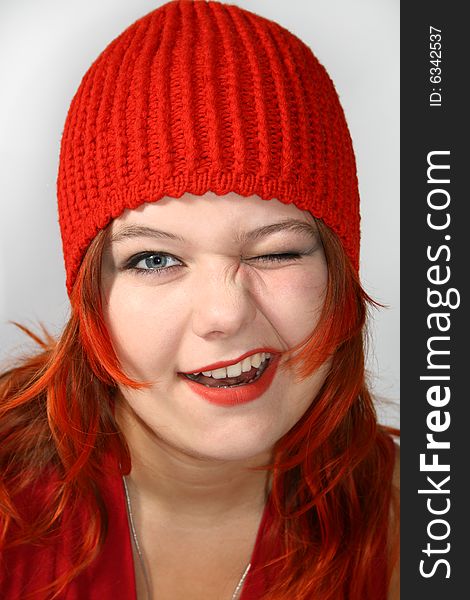 Attractive, merry girl in the red cap winks. Attractive, merry girl in the red cap winks
