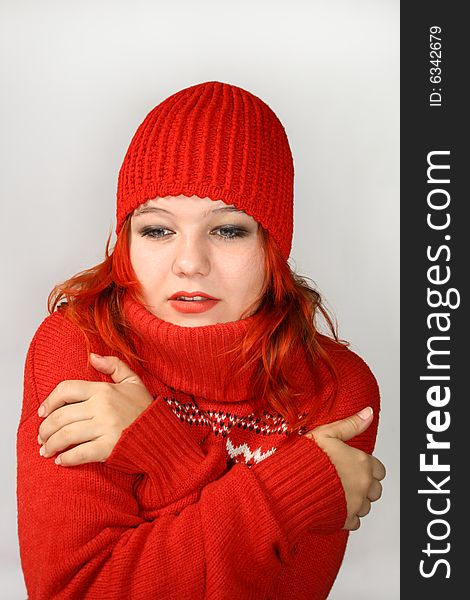 Young girl hides into the collar of the red sweater. Young girl hides into the collar of the red sweater