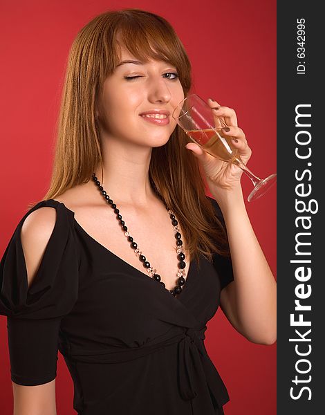 Winking girl with champagne glass isolated on red background
