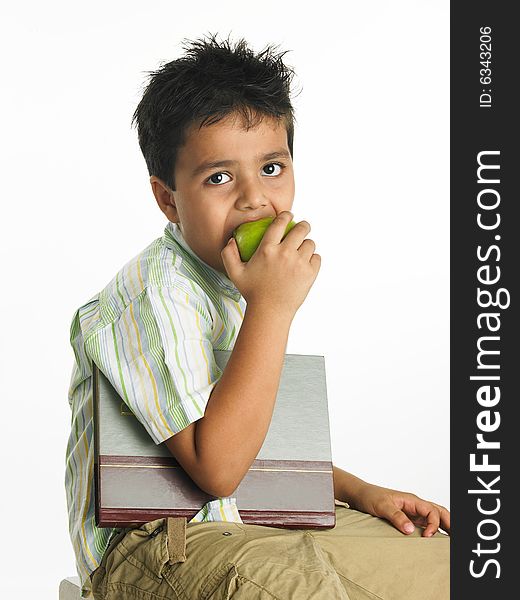 Asian boy of indian origin eating a green apple. Asian boy of indian origin eating a green apple