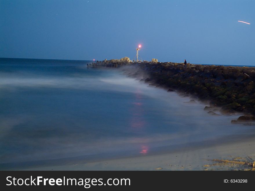 Ocean at night with long exposure showing inlet jetty. Ocean at night with long exposure showing inlet jetty