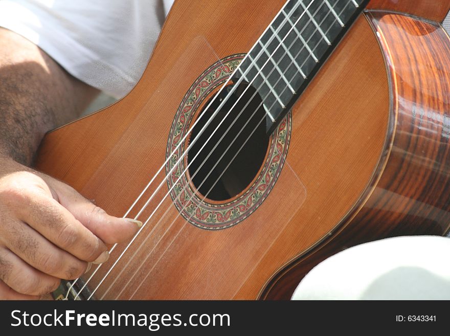 A male playing a classical guitar. A male playing a classical guitar