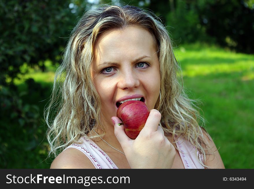 Woman eating apple in garden