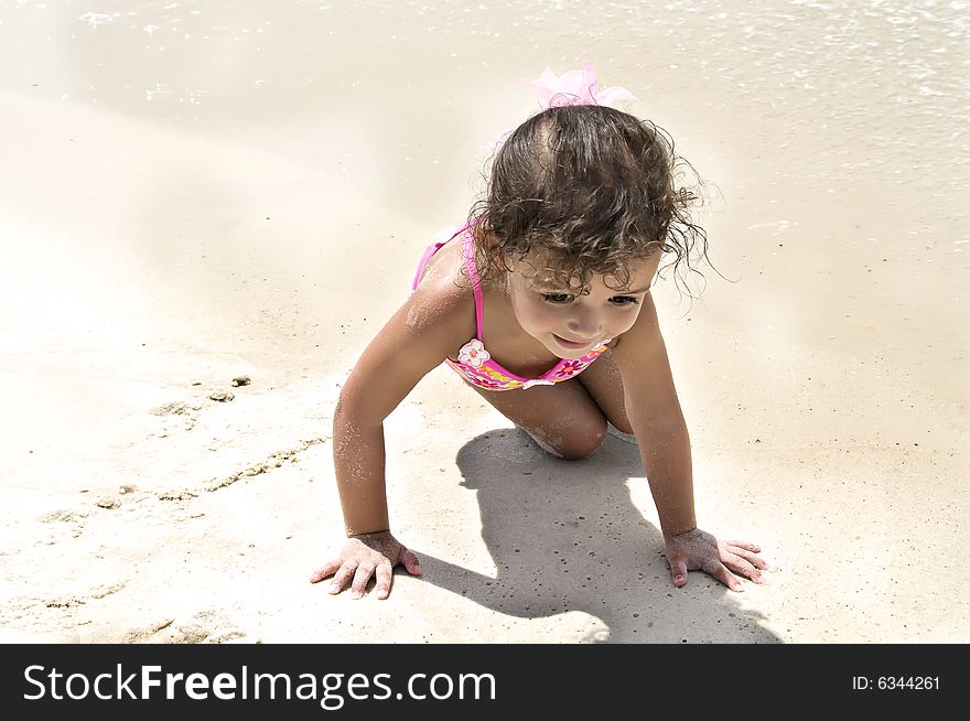 A young baby girl crawling on the beach. A young baby girl crawling on the beach.