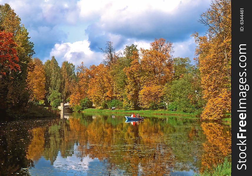 Autumn trees and pond with a boat. Autumn trees and pond with a boat