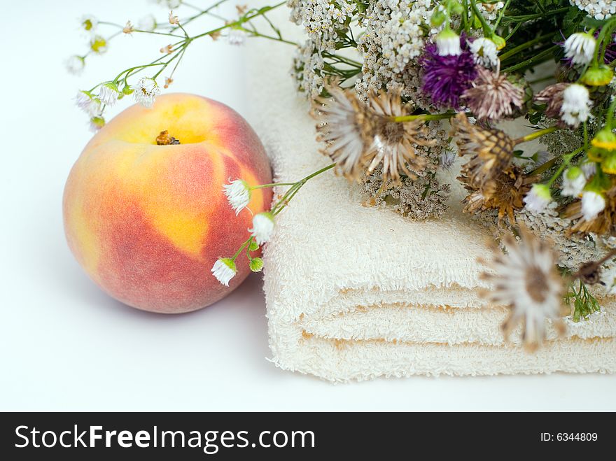 Healthy lifestyle background with peach, towel and flowers. Healthy lifestyle background with peach, towel and flowers