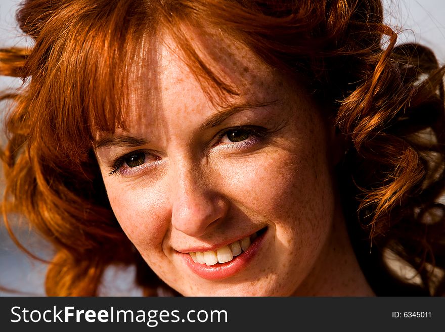 Close-up bright portrait of red-haired lovely young woman outdoors. Close-up bright portrait of red-haired lovely young woman outdoors