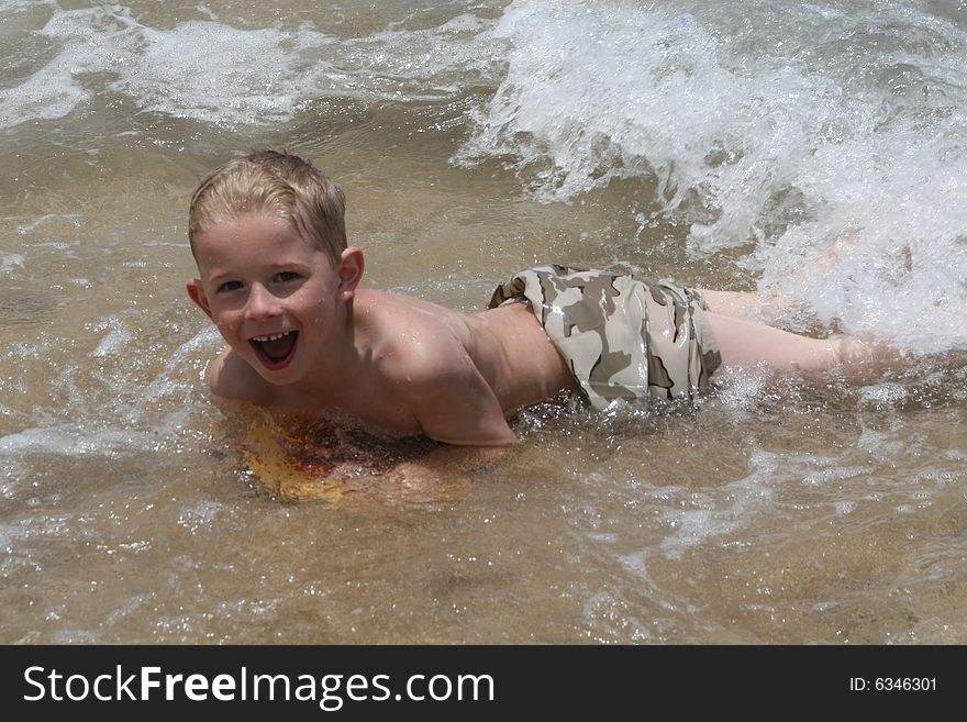 Little boy swimming in the waves