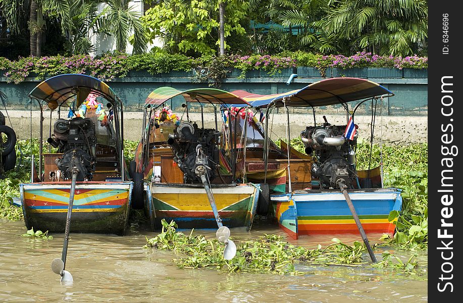 Three longtail riverboats moored along the Chao Praya river in Bangkok, Thailand. Three longtail riverboats moored along the Chao Praya river in Bangkok, Thailand