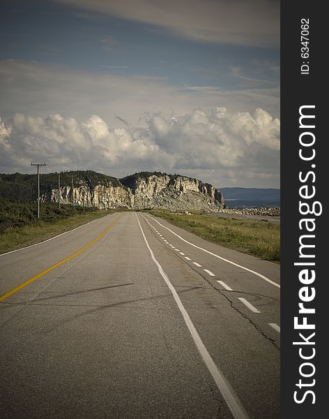 Empty road on a rocky coast line with skid marks on the concrete. Newfoundland Canada. Empty road on a rocky coast line with skid marks on the concrete. Newfoundland Canada.