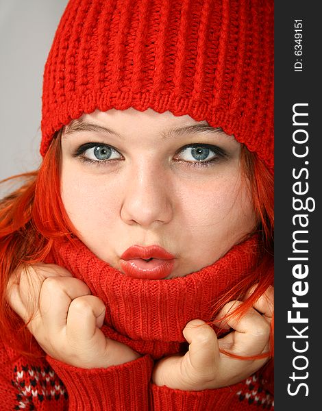 Young girl hides into the collar of the red sweater. Young girl hides into the collar of the red sweater
