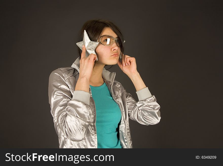 Fashion girl listening to stars isolated on black background