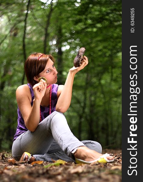 A picture presents a girl holding a mushroom in hands. A picture presents a girl holding a mushroom in hands
