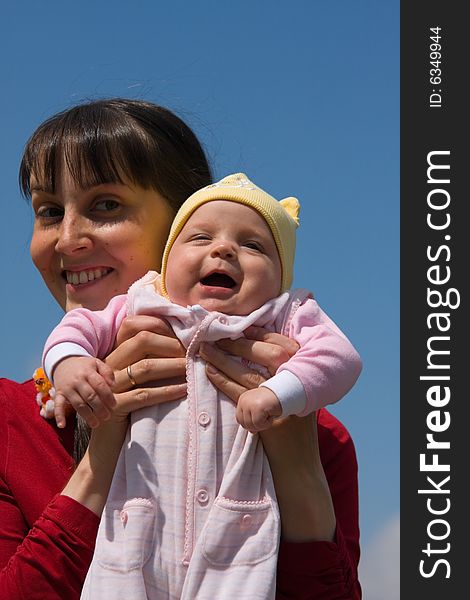 Baby with mom on blue sky background