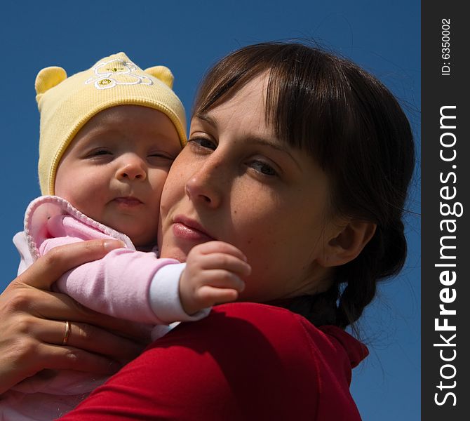 Baby with mom on blue sky background