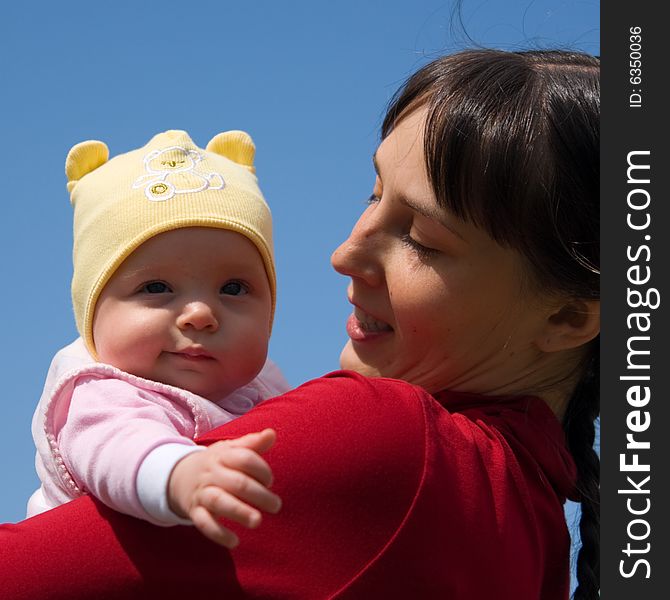 Baby with mom on blue sky background