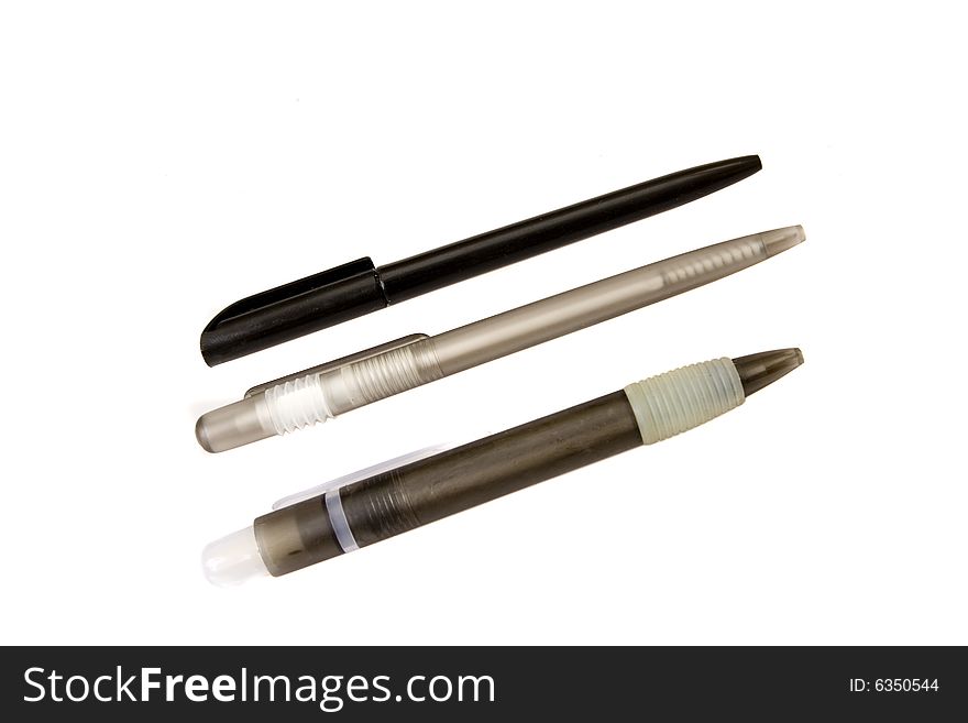 Three black plastic pens on white ground