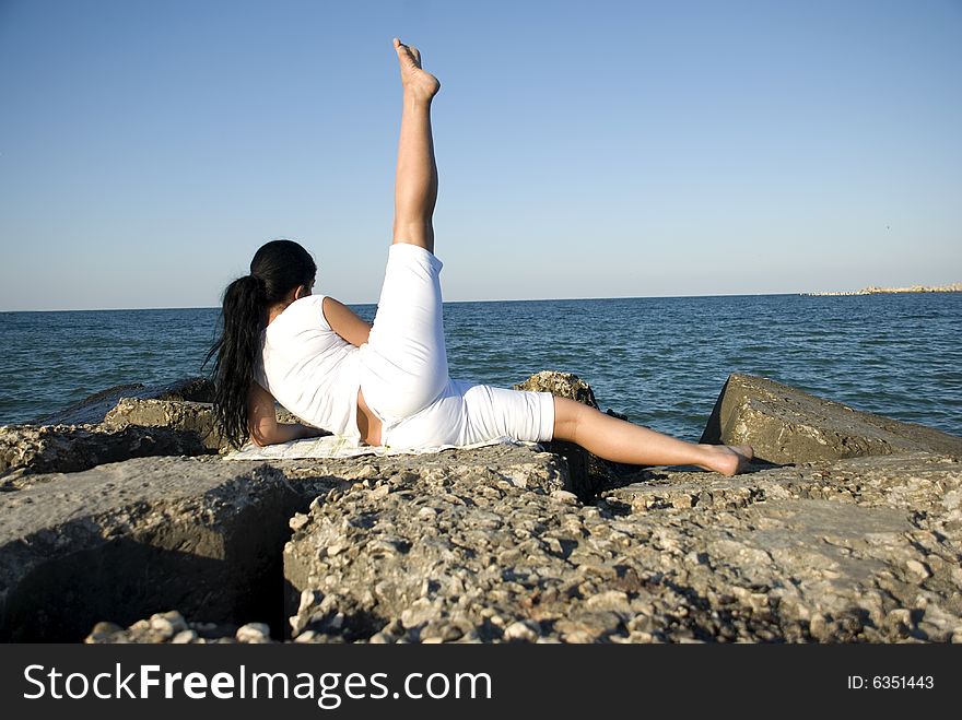 Women making exercises on rocks,on beach,trying to be healthy ,more photos with this model in Sport,yoga,fitness. Women making exercises on rocks,on beach,trying to be healthy ,more photos with this model in Sport,yoga,fitness